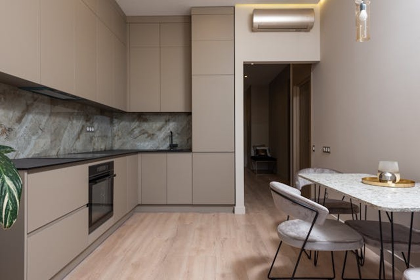 inside of a kitchen with marble and a light brown colour for its walls and cabinets
